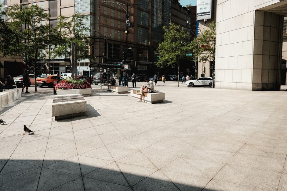 Mobilidade Urbana — A bustling urban plaza on a sunny day in downtown Chicago with people and pigeons.